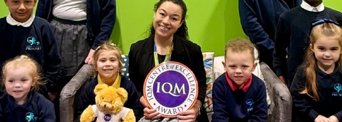A staff memebr and students sat with the IQM Award